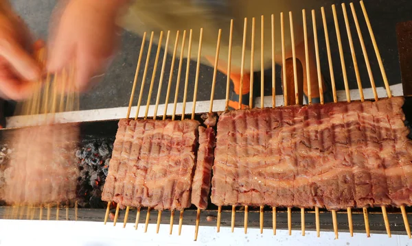 Espetos de carne de cordeiro cozidos na grelha durante as feas da aldeia — Fotografia de Stock