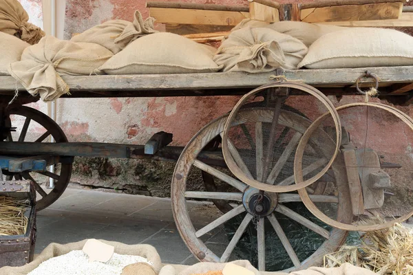 Wagon with wooden wheels and the jute sacks over — Stock Photo, Image