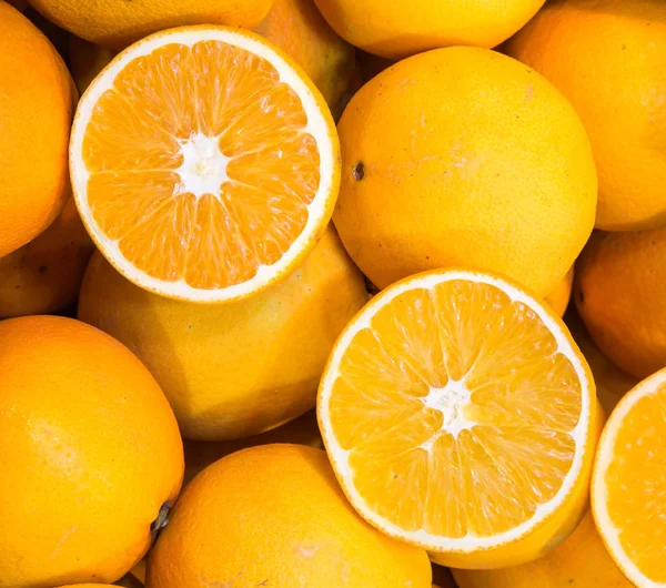 Pomarańczowy tło dojrzałe, soczyste pomarańcze na sprzedaż — Zdjęcie stockowe