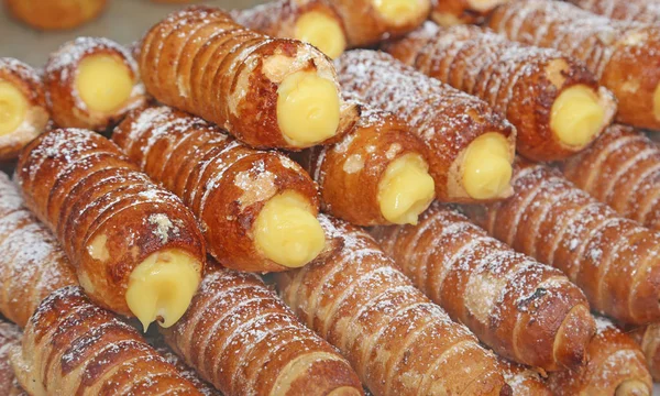 Cannoli ripieni di crema pasticcera in vendita in pasticceria — Foto Stock