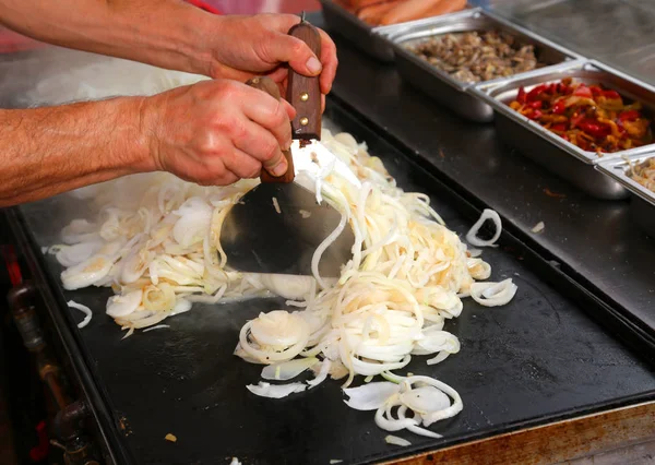 Chef cozinhar cebolas durante a preparação do almoço em um outdoo — Fotografia de Stock