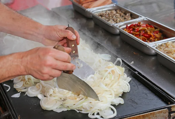 Chef especialista cozinhar cebolas durante a preparação do almoço — Fotografia de Stock
