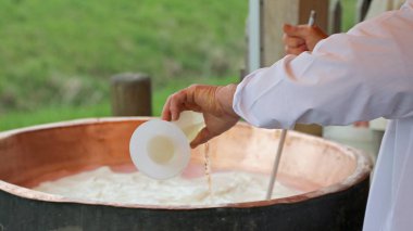 Cheesemaker c yapmak büyük bakır kazana peynir mayası dökün