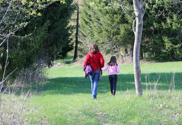 Joven madre y su pequeña niña caminando — Foto de Stock