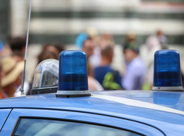 Δύο μπλε φώτα σειρήνα του ένα αυτοκίνητο της αστυνομίας και πολλοί άνθρωποι — Φωτογραφία Αρχείου