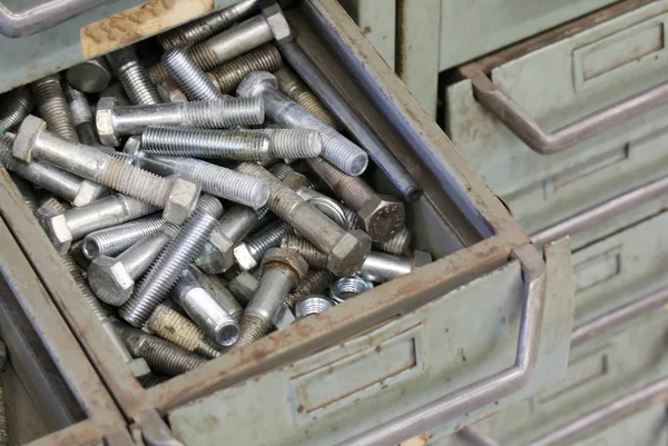 Pernos de hierro en un cajón en la vieja ferretería — Foto de Stock