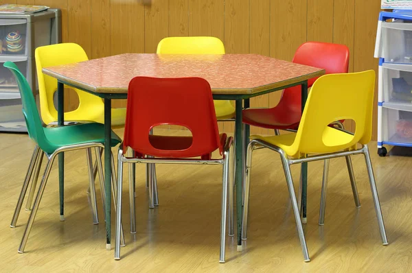 Cadeiras ao redor da mesa hexagonal na sala de aula — Fotografia de Stock