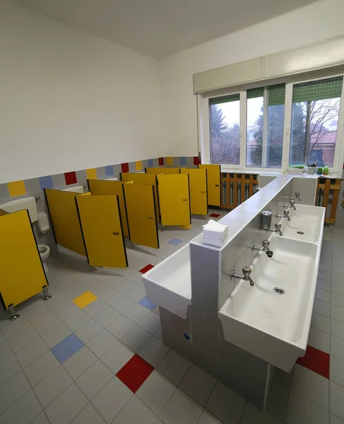 Inside a bathroom of a nursery school with small toilets and sin — Stock Photo, Image