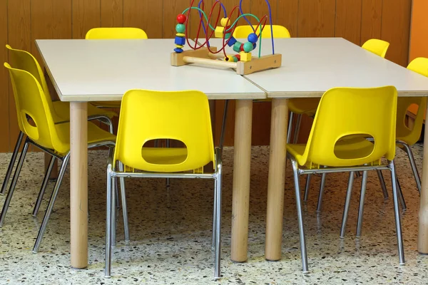 Sillas amarillas con un juguete sobre el escritorio dentro del vivero —  Fotos de Stock