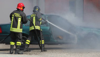 İtalyan itfaiyeciler araba yangınında araba kazasından sonra söndürüldü.