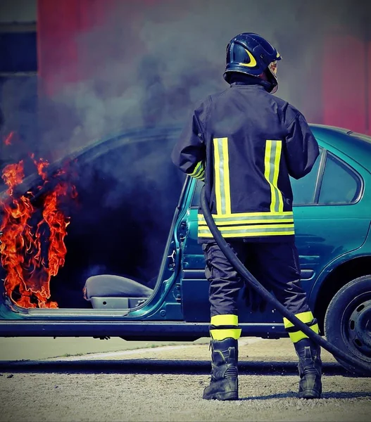 Pompiere durante chiusura di un fuoco di un'auto — Foto Stock