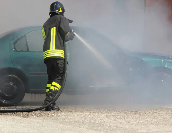 Пожежник гасить пожежу автомобіля — стокове фото