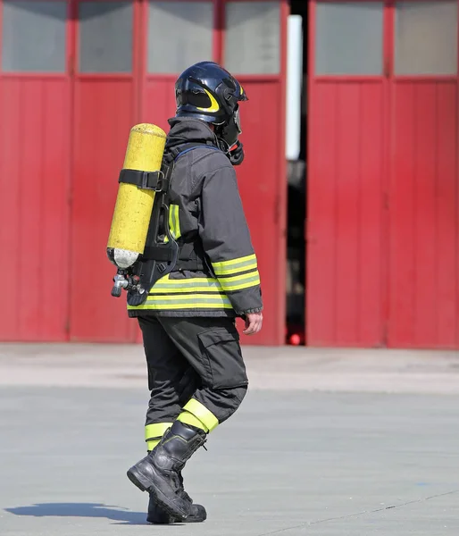Пожежник з кисневим баком, щоб дихати під час вогню — стокове фото