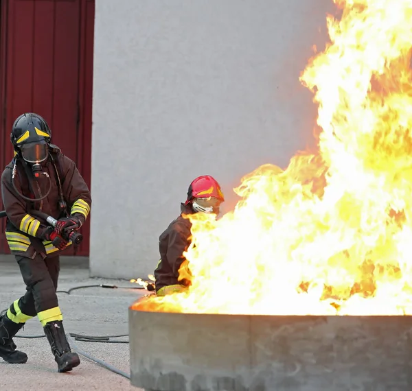 Bomberos durante un ejercicio de entrenamiento frente a un enorme fuego en la b —  Fotos de Stock
