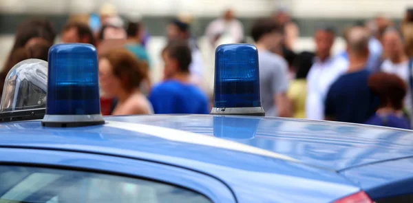 Zwei Blaulichter eines italienischen Polizeiwagens und viele Menschen — Stockbild Blaulicht eines italienischen Polizeiwagens und viele Menschen — Stockfoto