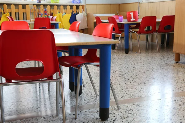 Cadeiras vermelhas com pequenos bancos dentro de um jardim de infância para crianças — Fotografia de Stock