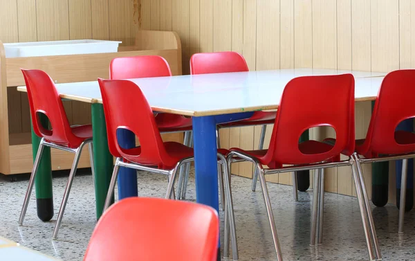 Rote Stühle mit kleinen Bänken einer Vorschule — Stockfoto