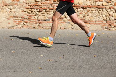 adam arka plan üzerinde spor giyim ve tuğla duvar ile çalışır