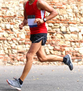 Runner hızlı yarış kasabada bir asfalt yol üzerinde çalışır