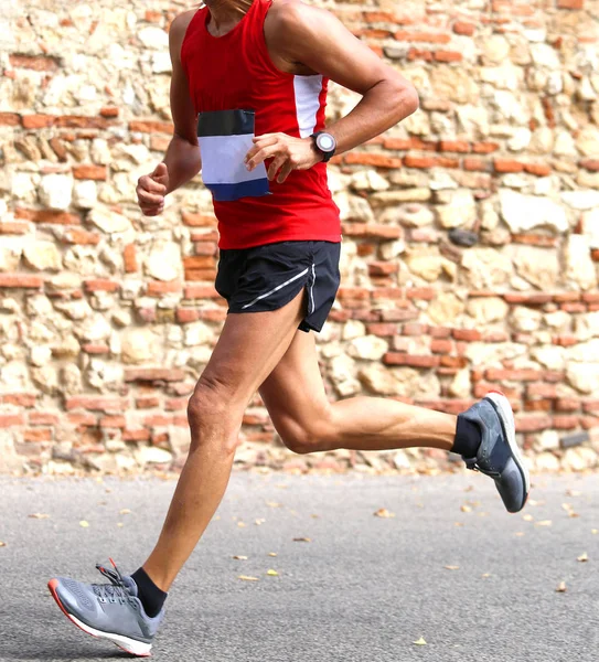 Corredor corre corrida rápida na cidade em uma estrada pavimentada — Fotografia de Stock