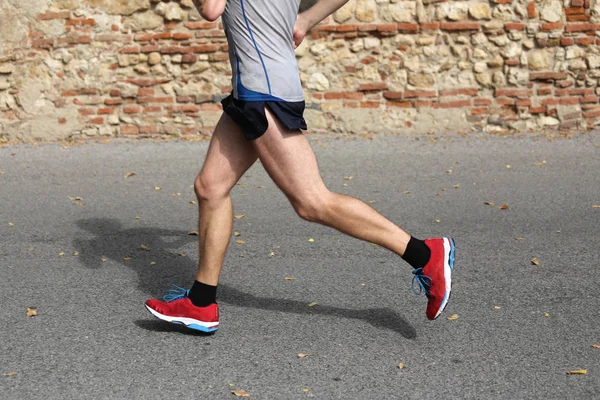 Швидкий бігун працює швидко з червоним спортивним взуттям на асфальті ro — стокове фото