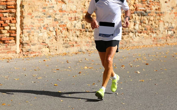 Coureur senior fonctionne avec des vêtements de sport et de briques arrière-plan — Photo