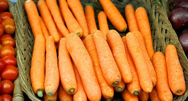 Корзина апельсиновой моркови на продажу в зеленом магазине — стоковое фото