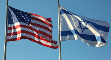 Mavi gökyüzünde sallayarak Amerika ve İsrail bayrakları