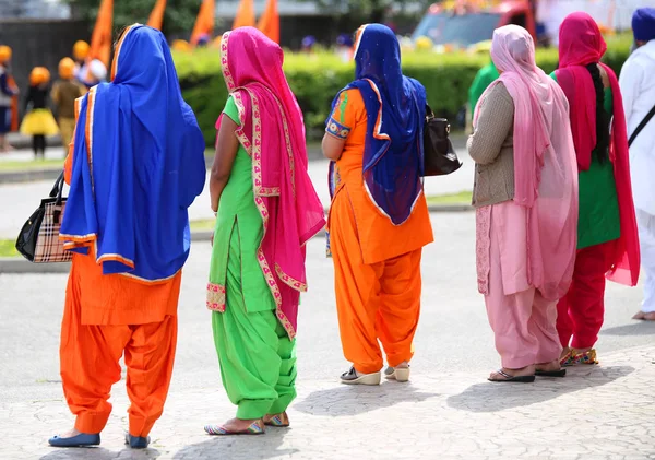 Багато жінок з різнокольоровими сукнями — стокове фото