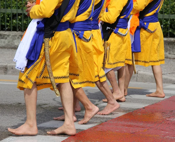 Cinco hombres con vestidos largos caminando descalzos por las calles — Foto de Stock