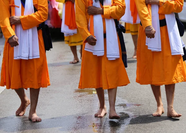 Hombres descalzos de la religión sij con ropa naranja larga caminan desnudos —  Fotos de Stock