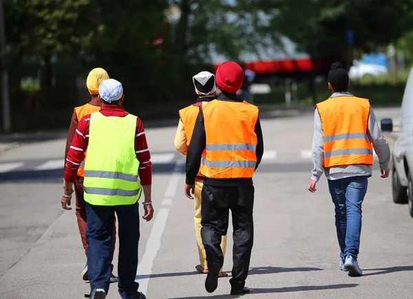 Young boys with turbans and the high visibility jackets walking — Stock Photo, Image