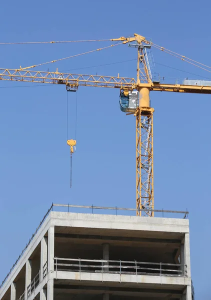 Edificio in costruzione e una gru gialla — Foto Stock