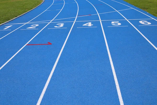 Corsie di una pista atletica blu con i numeri uno due tre quattro f — Foto Stock