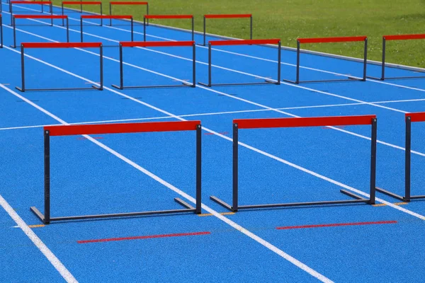 Obstáculos vermelhos na pista de corrida azul durante uma corrida — Fotografia de Stock