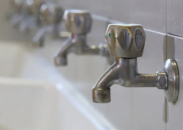 Stainless steel taps in a sink of a school for the infancy — Stock Photo, Image