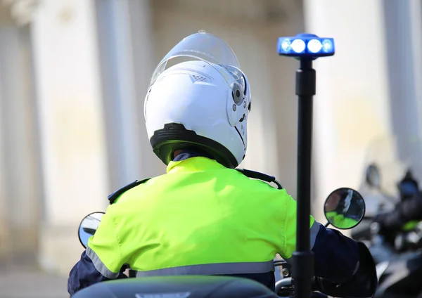 Oficial de policía en motocicleta con sirena azul intermitente en la ciudad —  Fotos de Stock