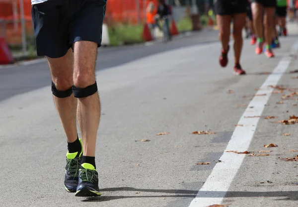 Corredor atlético con banda elástica en la rodilla corriendo rápido durin — Foto de Stock