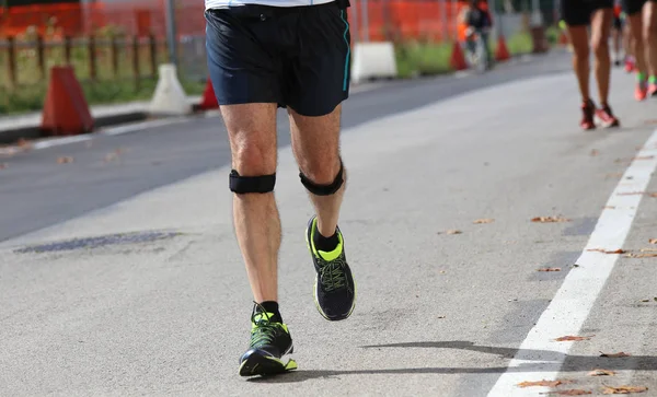 Atlético corredor com a faixa elástica durante a corrida — Fotografia de Stock