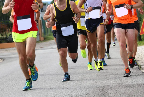 Pernas musculares de corredores durante a corrida esportiva pelas ruas — Fotografia de Stock