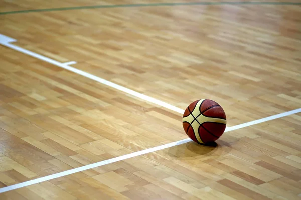 Баскетбольный мяч над деревянным паркетом — стоковое фото