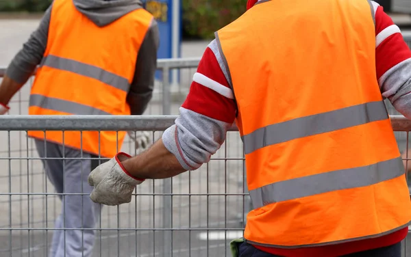 Workers with orange high-visibility vest while moving the iron f — Stock Photo, Image