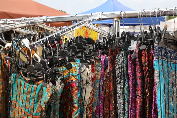 Stand auf einem Outdoor-Markt mit vielen Kleidungsstücken, die zum Verkauf stehen — Stockfoto