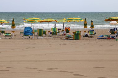 kaba deniz ve plaja birçok şemsiye ile