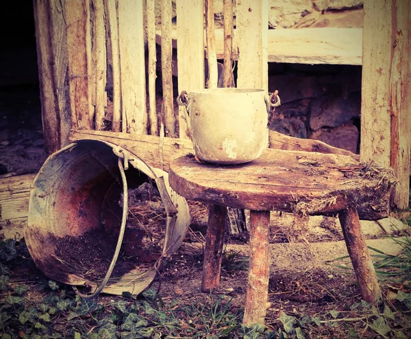 Alter kaputter Eimer und eine Aluminiumpfanne auf dem Holzhocker — Stockfoto