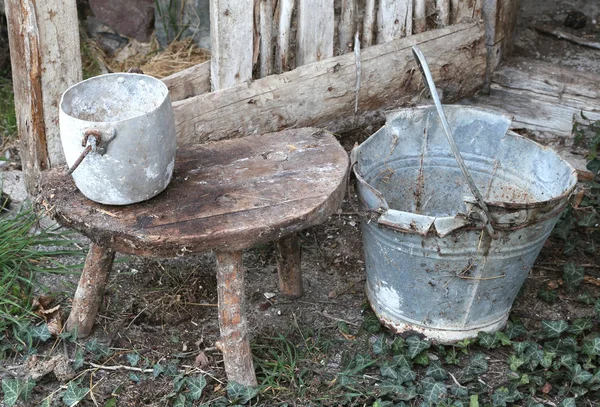 Verlaten schuur een oude gebroken emmer en een aluminium pan — Stockfoto