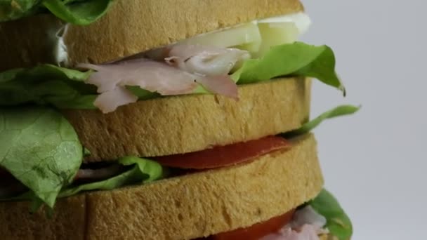 GANT σάντουιτς γεμιστό με πολλά στρώματα του ψωμιού με μαρούλι ντομάτα τυρί σαλάμι — Αρχείο Βίντεο
