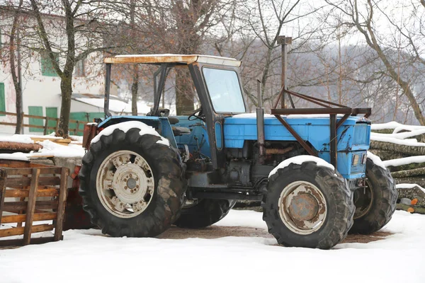 Blå gammal traktor på en gård i vinter — Stockfoto