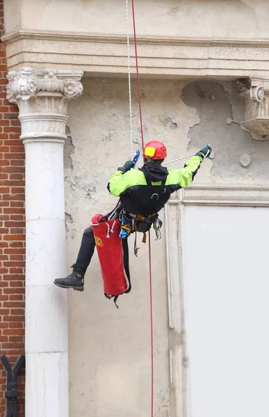 Valiente bombero trepando con cuerdas en un viejo edificio para mon —  Fotos de Stock