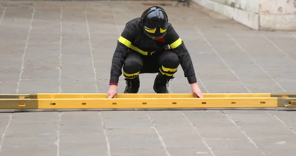 Brandweerman tijdens het monteren van de ladder tijdens een noodsituatie — Stockfoto